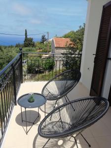 a patio with two chairs and a table on a balcony at Villa Clio in Mánganos