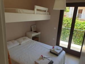 a bedroom with a white bed and a large window at Villa Clio in Mánganos