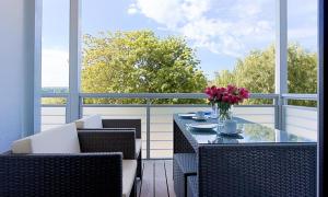 einen Tisch mit einer Blumenvase auf dem Balkon in der Unterkunft Blue Sky in Dierhagen