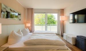 1 Schlafzimmer mit 2 Betten und einem großen Fenster in der Unterkunft Blue Sky in Dierhagen
