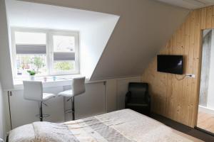 um quarto com uma cama, uma secretária e uma janela em B&B Hartje Spakenburg em Spakenburg