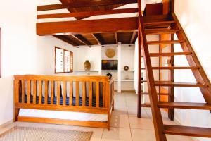 a room with a wooden staircase and a living room at Jeri Pousada in Jericoacoara
