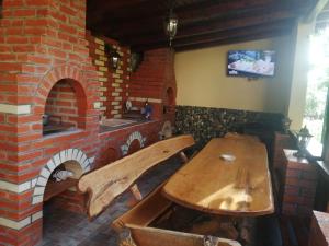 ein Holztisch vor einem Steinofen in der Unterkunft CASA NIRVANA in Dubova
