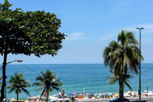 uma vista para a praia com palmeiras e o oceano em Ponto chave no Leblon - 50m da praia - GU301 Z1 no Rio de Janeiro