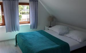a bedroom with a bed and a window with curtains at Pelikan in Niechorze
