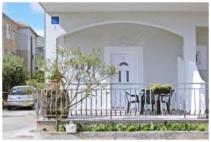Casa blanca con 2 sillas y porche en Apartments & Room Dijana, en Trogir