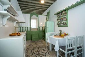 a kitchen with green cabinets and a table in a room at Marouli Traditional House in Koskinou