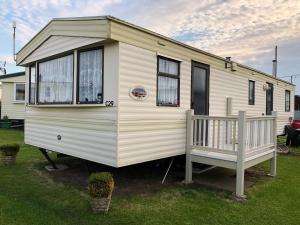 BactonにあるNorfolk Poppy Caravan - Sleeps 4 - WiFi and Sky TV Includedの白いキャラバン(ポーチ付)