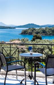 een tafel en stoelen op een balkon met uitzicht op het water bij Spiros Sea View in Nydri