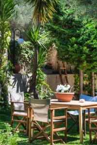 a wooden table and chairs in a garden at Spiros Sea View in Nydri