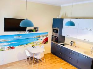 a kitchen with a dining table and a painting on the wall at Kuninga Old Town Resident in Pärnu