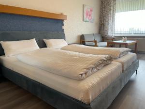 a large bed in a room with two beds at Seehotel Geestland in Bad Bederkesa