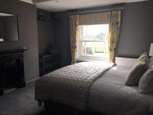 um quarto com uma cama grande e uma janela em Cosy Lincs Wolds cottage in picturesque Tealby em Tealby