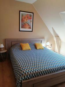 ein Bett mit zwei gelben Kissen in einem Schlafzimmer in der Unterkunft Chez Valérie in Merlevenez