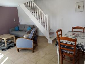 - un salon avec un escalier, une table et des chaises dans l'établissement Chez Julien, à Montviron