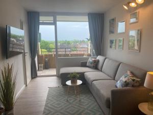 ein Wohnzimmer mit Couch und großem Fenster in der Unterkunft Stylische Ferienwohnung TOP LAGE am Hafen, Strand und Meer in Wendtorf
