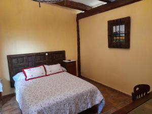 a bedroom with a bed with a wooden headboard and a window at Casa Blanca in Alhama de Aragón