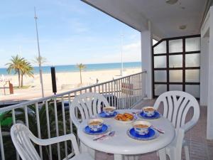 a table with plates of food on a balcony with the beach at BONAIRE - PRIMERA LÍNEA DE PLAYA in Playa de Gandia