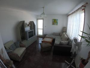 a living room with a couch and a tv at Villa Trakia in Golden Sands