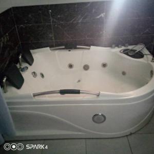a white bath tub sitting in a bathroom at luxury 4 bed rooms duplex lekki Lagos nigeria in Lekki