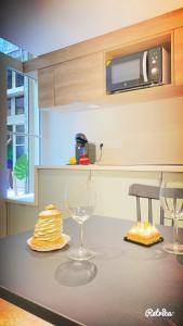 a kitchen counter with two wine glasses and a microwave at Studio Zen Tokyo in Lyon