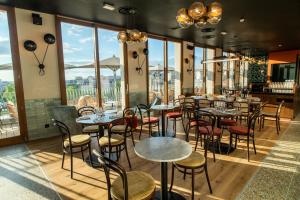 a restaurant with tables and chairs and large windows at The People - Paris Nation in Paris