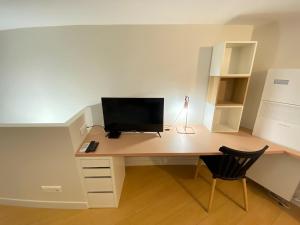 a computer desk with a monitor and a chair at Studio Zen Tokyo in Lyon