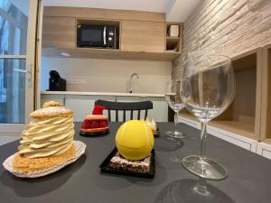a table with two wine glasses and cakes on it at Studio Zen Tokyo in Lyon