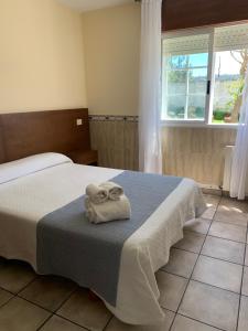 a bedroom with a bed with two towels on it at APARTAMENTOS TURÍSTICOS CASA SANDRA in Sanxenxo