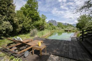 una terraza de madera con mesa de picnic junto a un estanque en IseoLakeRental - Villa Dossello, en Solto Collina