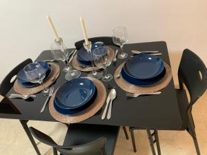 a black table with blue plates and wine glasses at Arista Sur in La Restinga