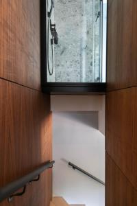 ein Bad mit einer Dusche und einem Glasfenster in der Unterkunft The Roebbek x Hanse in Hamburg