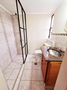 a bathroom with a shower and a sink and a toilet at Raíces Hostería Boutique in Sierra de la Ventana +31 photos