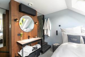 Schlafzimmer mit einem Bett, einem Waschbecken und einem Spiegel in der Unterkunft The Roebbek x Hanse in Hamburg