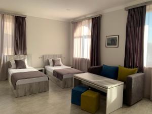 a hotel room with two beds and a couch at Menua by Horizon Hotels, Yerevan in Yerevan