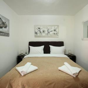 a bedroom with a large bed with two white towels on it at Apartments & Dream Rooms in Niš