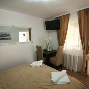 a bedroom with a bed and a table and a window at Apartments & Dream Rooms in Niš