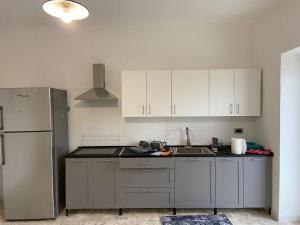 a kitchen with white cabinets and a sink and a refrigerator at Villa Baccile in Fossacesia