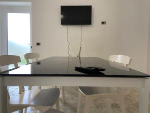 mesa de comedor con sillas y TV en la pared en Villa Baccile en Fossacesia
