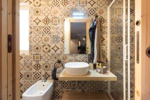 La salle de bains est pourvue d'un lavabo et d'un miroir. dans l'établissement MenzaTesta - Casa indipendente con terrazzo, à Raguse
