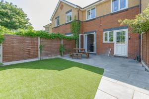 a backyard with a wooden fence and a picnic table at Avella by the Park in Lytham St Annes