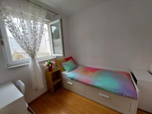 - une petite chambre avec un lit et une couverture colorée dans l'établissement Apartment Vira, à Makarska