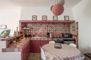cocina con mesa y cocina con armarios rojos en Maison Ventoux 2 Luxe Calme Central Linge fourni en Malaucène