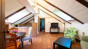 uma sala de estar no sótão com uma mesa e cadeiras em Alojamiento Rural Molino Del Puente em Dúrcal