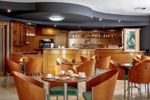 a restaurant with tables and chairs and a kitchen at Euro Hotel in Nuoro