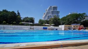 a large swimming pool with a building in the background at Luxury Apartments Alix in Burgas