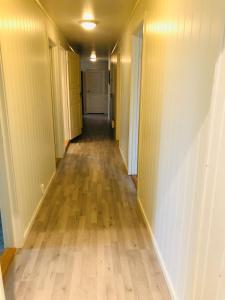 an empty hallway of an apartment with wood floors at 7 Roms Gjeste leilighet in Alstahaug