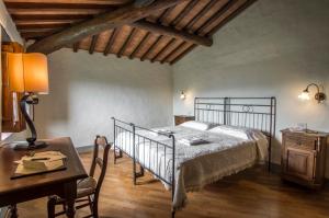 een slaapkamer met een bed, een tafel en een bureau bij Podere La Casaccia in Poppi
