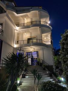 a large white building with stairs at night at Garden Boutique Hotel in Elbasan