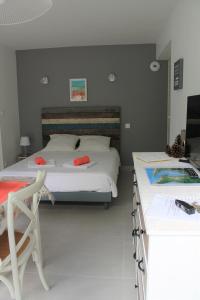 1 Schlafzimmer mit 2 Betten, einem Stuhl und einem Schreibtisch in der Unterkunft MAGNIFIQUES APPTS à côté DE LA PLAGE in Andernos-les-Bains